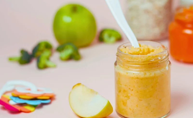 Baby puree on a jar with spoon on it.